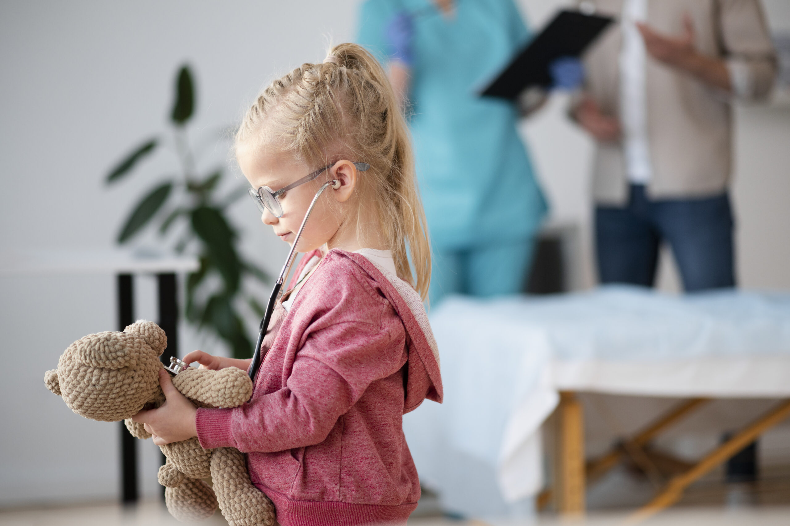 Une petite fille écoute le coeur de son nounours